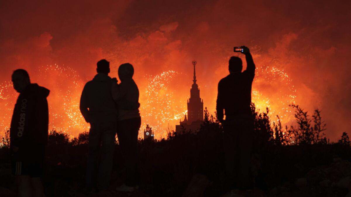 People watch and take pictures of the fireworks exploding over the Moscow's University during the celebration of the 75th anniversary of the Nazi defeat in World War II in Moscow, Russia. Photo: AP