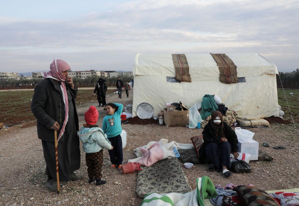 Earthquake survivor stands with his children and injured sister outside tents erected for people affected by a devastating earthquake, in Jandaris, Syria February 11, 2023. Photo: Reuters
