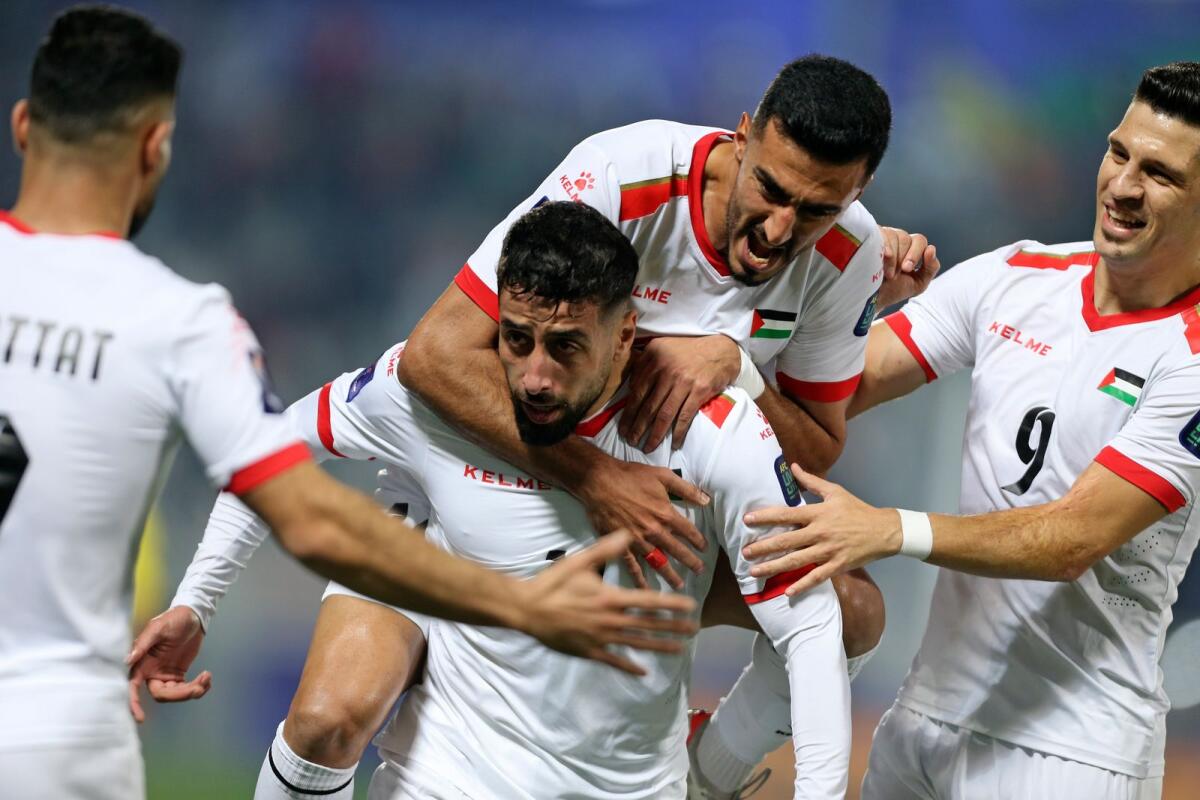 Palestine's Oday Dabbagh (centre) celebrates with teammates after scoring a goal against Hong Kong. — AP
