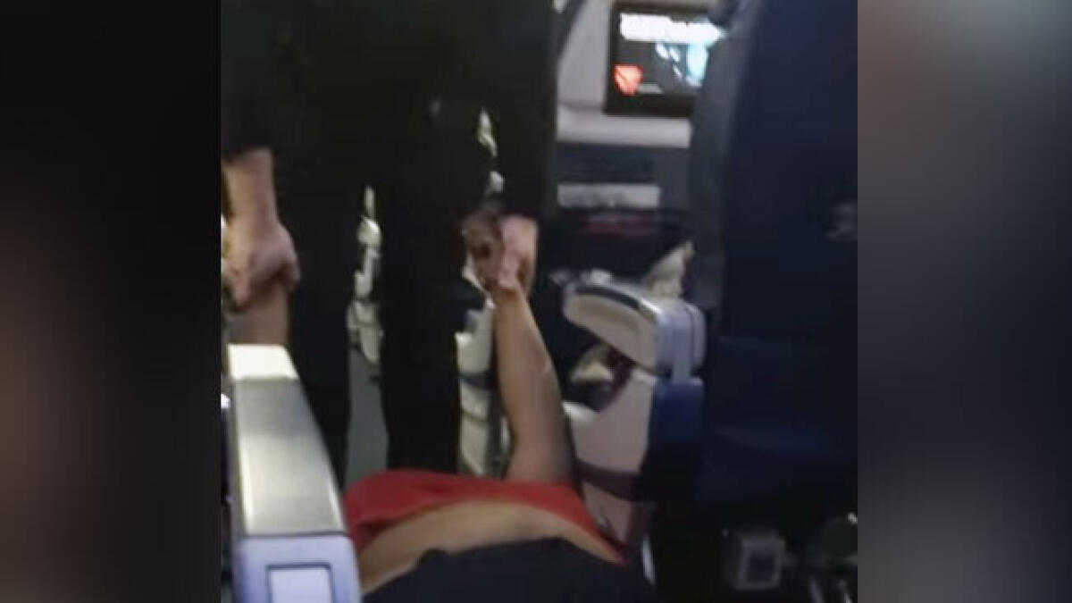 Watch: Woman dragged out of plane by cops