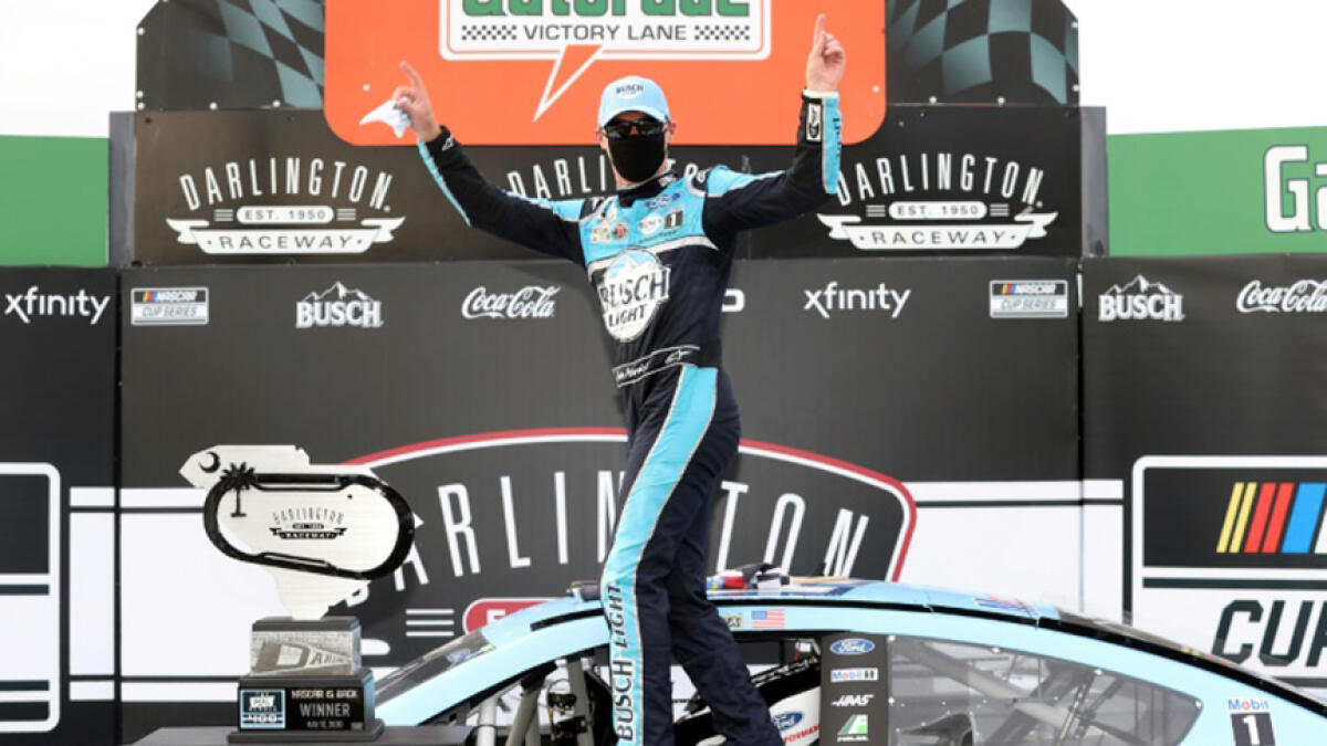 Kevin Harvick, sporting a black protective face mask, celebrates his victory after winning the NASCAR Series race at Darlington Raceway in South Carolina. -- AFP