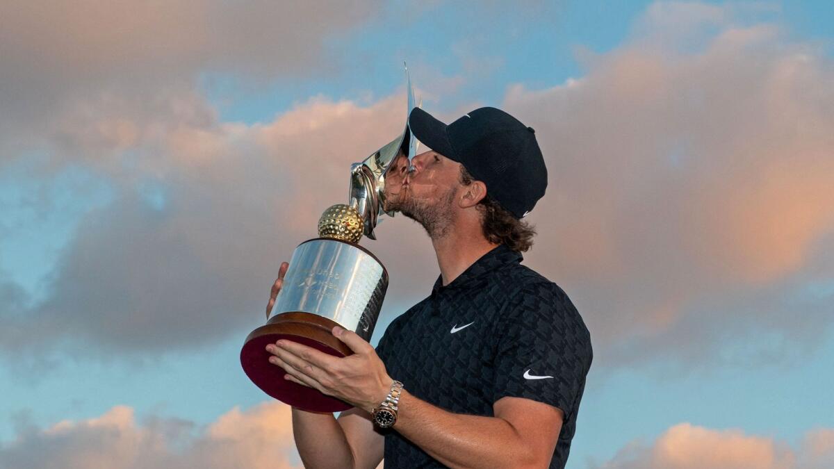 Thomas Pieters of Belgium kisses the trophy after winning the Abu Dhabi HSBC Golf Championship. (AFP)