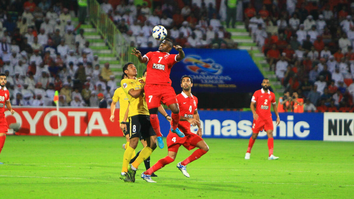 Al Ahli’s Ismail and Guangzhou Evergrande’s Paulinho clash during the first leg of the AFC Championship League final in Dubai. 