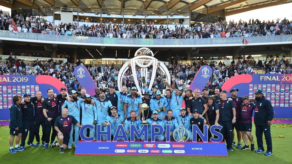 England's players and management pose for a group photograph with the World Cup trophy as England's players celebrate their win after the 2019 Cricket World Cup final between England and New Zealand at Lord's Cricket Ground in London. AFP