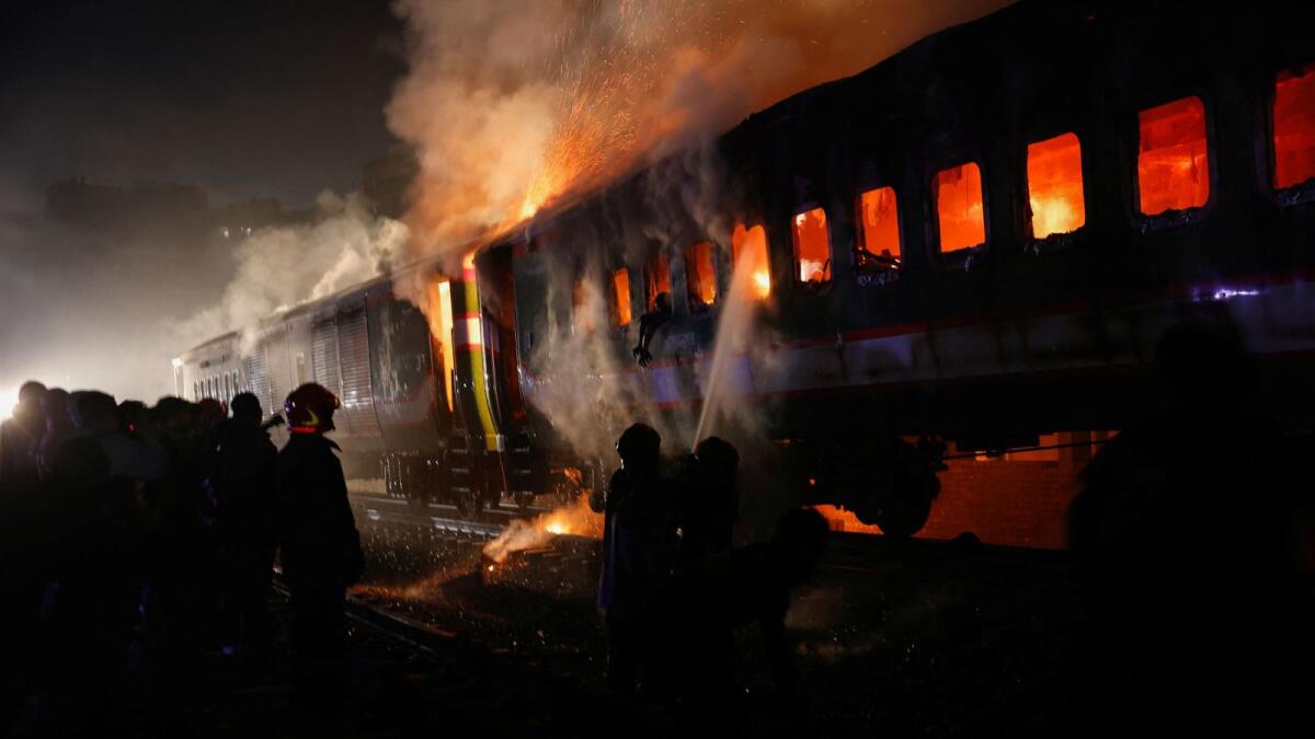 Firefighters try to extinguish a fire in a passenger train in Dhaka. — Reuters