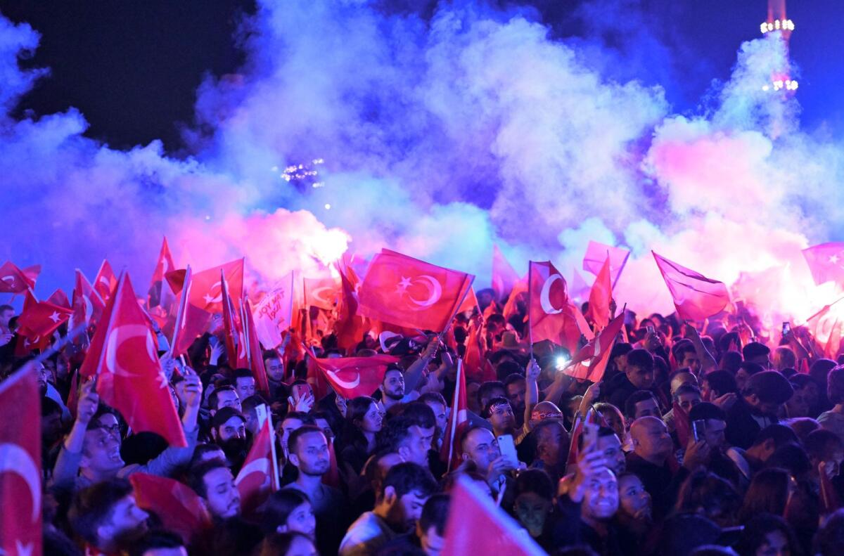 Opposition Republican People's Party supporters celebrate outside the main municipality building following municipal elections across Turkey, in Istanbul on March 31, 2024. — AFP