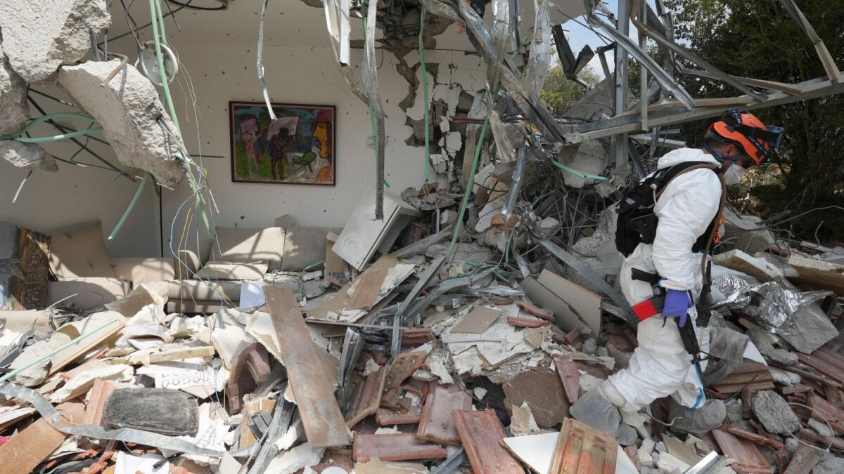 An Israeli soldier walks by a house destroyed by Hamas militants in Kibbutz Be'eri on Wednesday. — AP