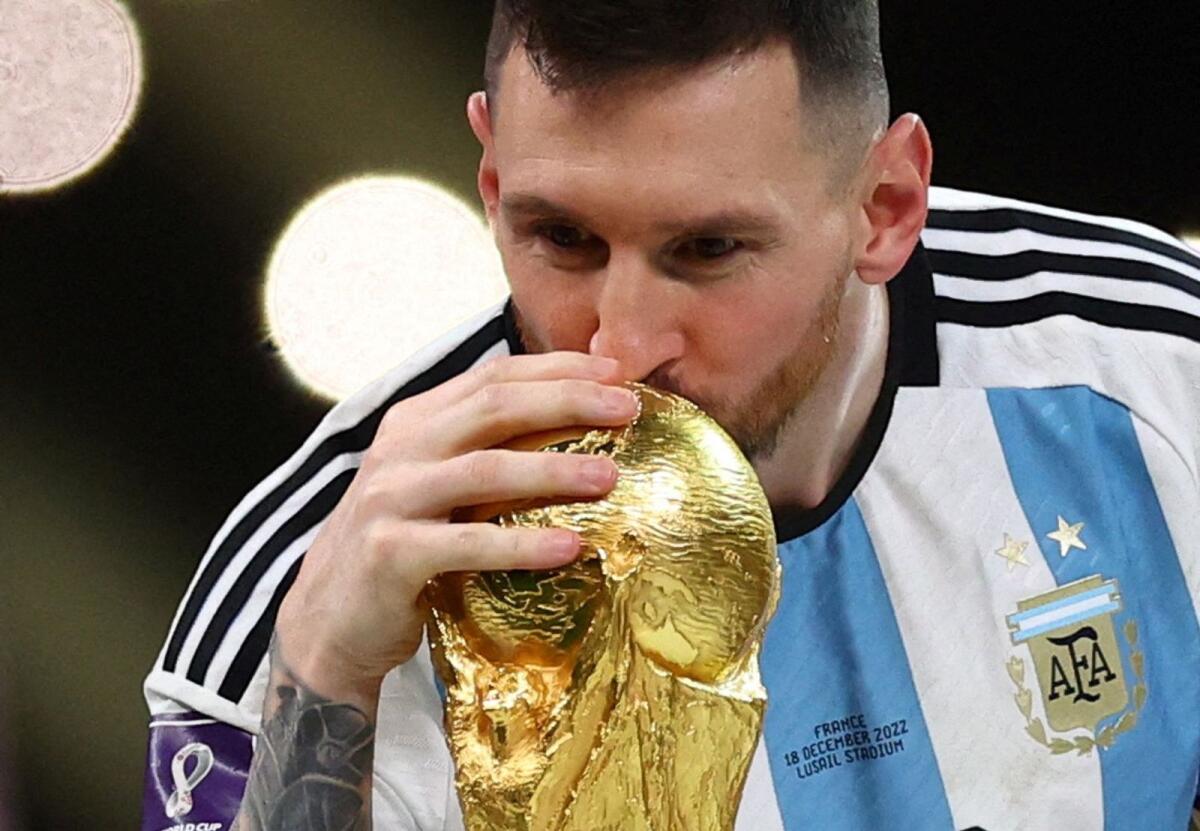 Argentina captain Lionel Messi kisses the trophy as he celebrates winning the World Cup — Reuters