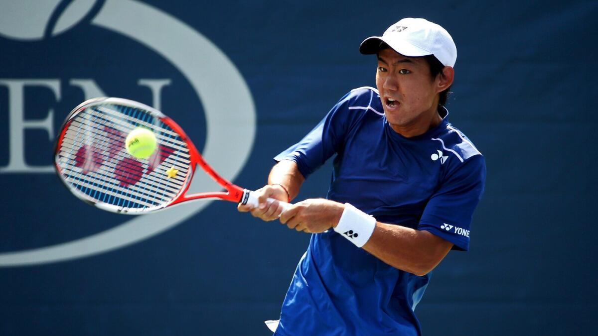 Yoshihito Nishioka of Japan returns a shot to Pierre-Hugues Herbert of France during their match at the US Open. 