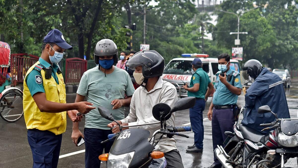 Police check identity documents at a check point during the lockdown and travel restrictions imposed to contain the spread of Covid-19 in Dhaka. Photo: AFP