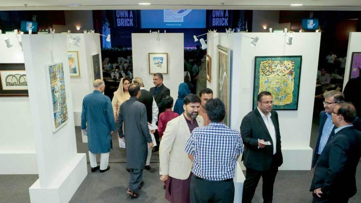 Visitors and artists during the calligraphic arts exhibition, ‘Silent Prayers’, at Pakistan Association Dubai. — Supplied photo