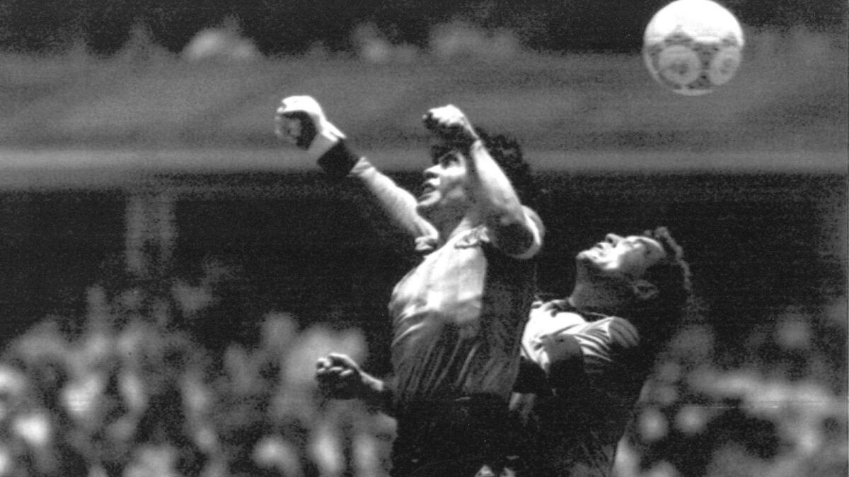Diego Maradona, left, beats England goalkeeper Peter Shilton to a high ball and scores his first of two goals in a World Cup quarterfinal soccer match, in Mexico City, in1986. - AP file
