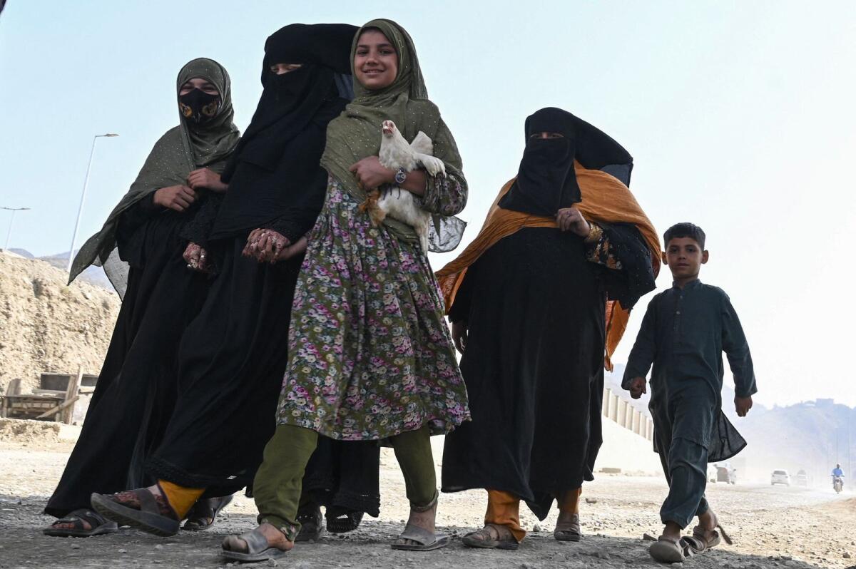 An Afghan refugee family arrives on foot to cross the Pakistan-Afghanistan Torkham border on November 2, 2023. — AFP