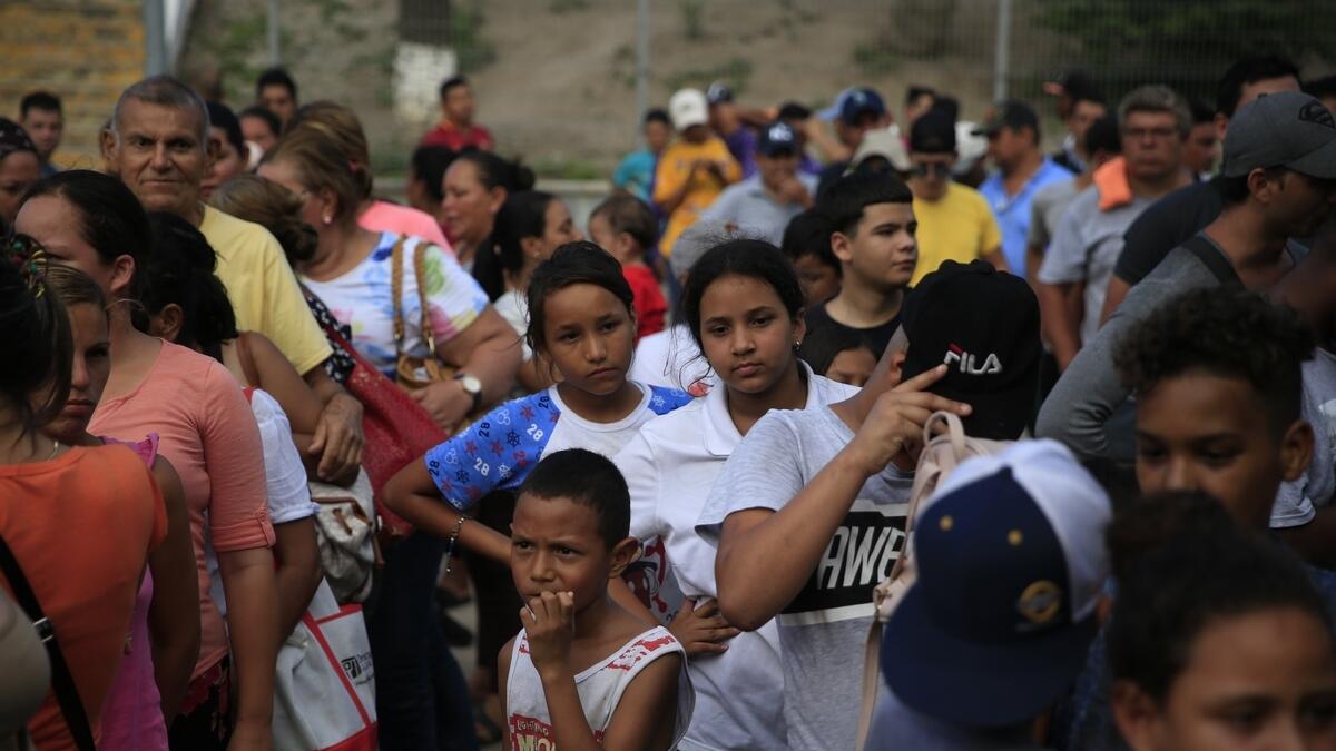 Migrants from countries including Honduras, Cuba, Venezuela, and Nicaragua, line up to receive a meal.- AP filr photo