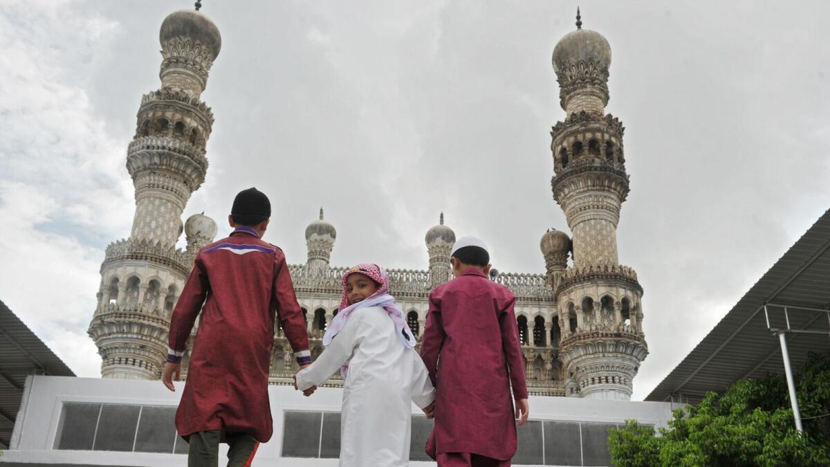 Indian boys walk towards Qutb Shahi Mosque to offer the last Friday prayers of the holy month of Ramadan, ahead of the Eid Al Fitr holiday, at  in Hyderabad.