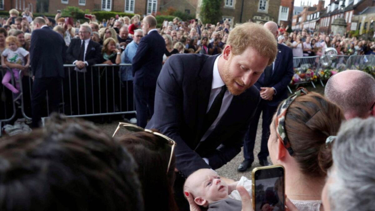 Prince Harry interacts with people outside the Windsor Castle.— Reuters