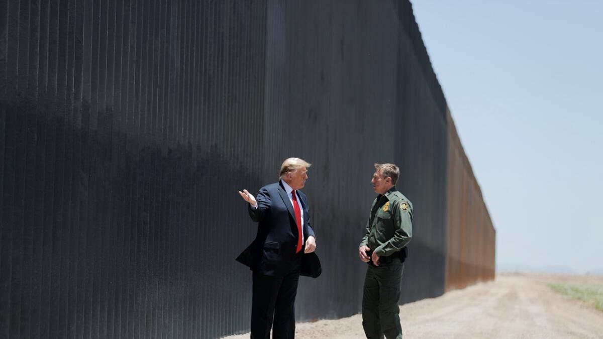 President Donald Trump talks with US Border Patrol Chief Rodney Scott as he tours a section of the US-Mexico border wall in San Luis, Arizona. Photo:  Reuters
