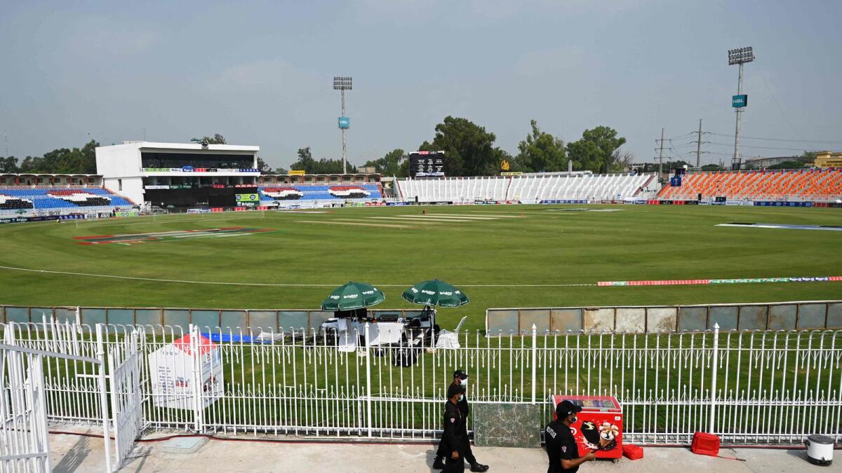 Pakistani policemen walk near the empty stands of the Rawalpindi Cricket Stadium. — AFP