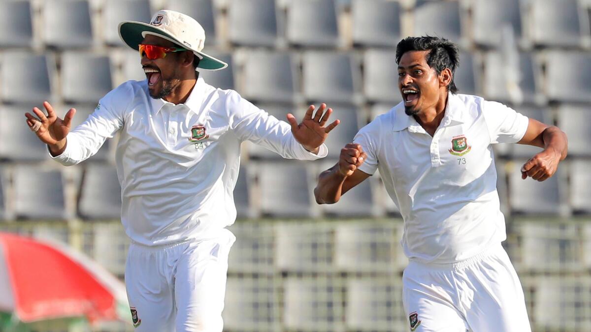Taijul Islam (R)  and skipper Najmul Hossain Shanto celebrate the dismissal of New Zealand's Henry Nicholls during the fourth day of the first Test cricket match at Sylhet, Bangladesh. - AP