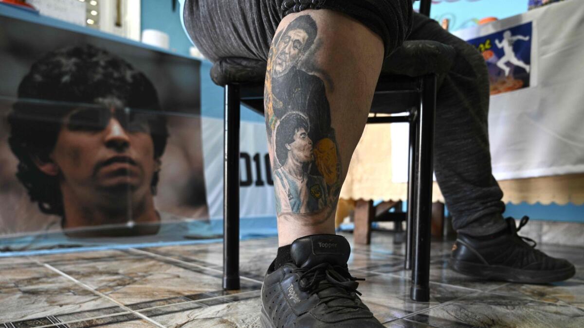 Pizza man Guillermo Rodriguez shows the tattoos on his leg depicting Argentinian football legend Diego Maradona, at his pizza store called 'Siempre al 10' (Always to the 10), referring to the jersey number of his idol, in Merlo, Buenos Aires province, Argentina. Rodriguez had this tattoo done to commemorate Maradona's 60th birthday. (AFP)