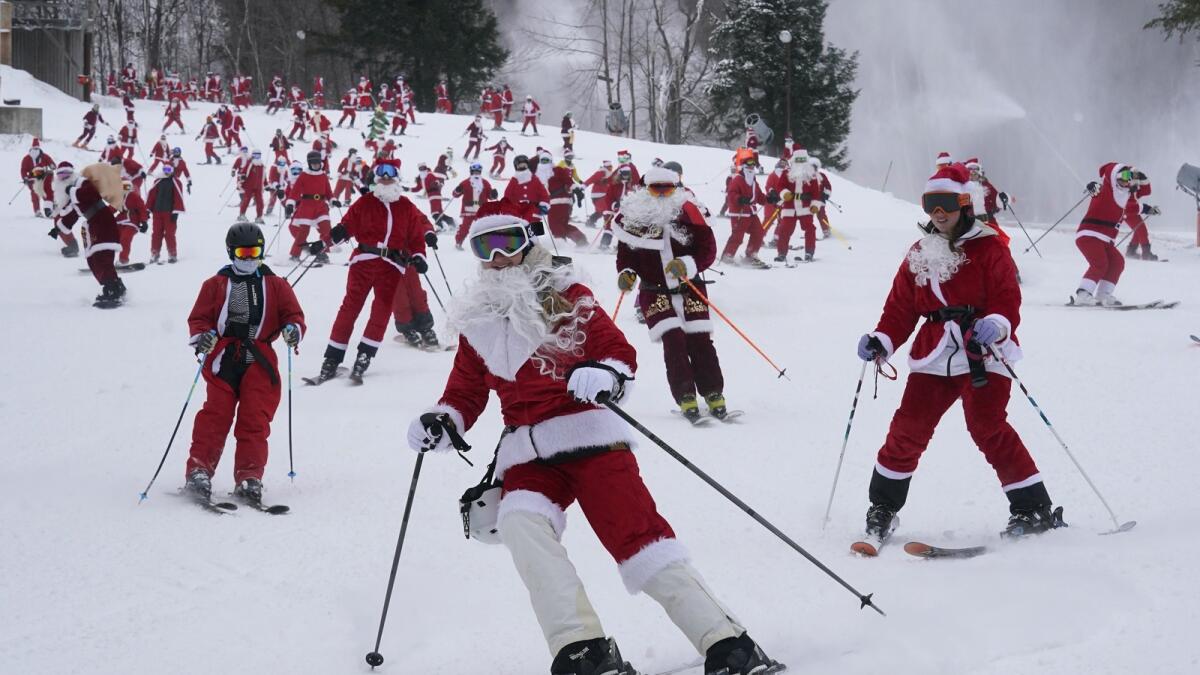 Skiers dressed in Santa Claus outfits hit the slopes for charity at the Sunday River Ski Resort. — AP photos