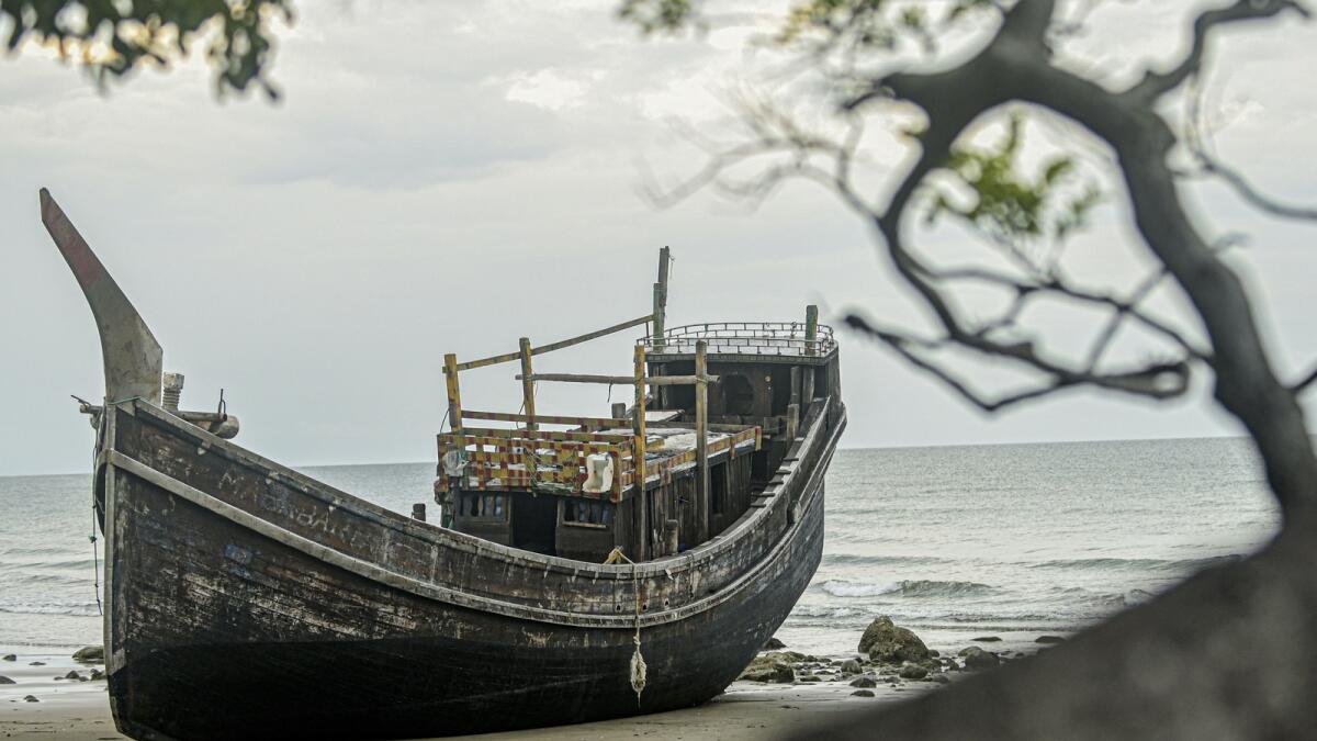 The boat used to carry a group of Rohingya Muslims sits on the beach where it landed in Pidie, Indonesia. — AP