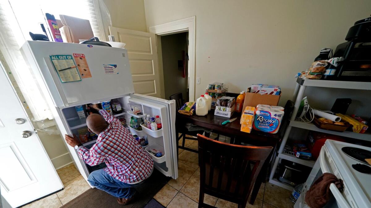 Norman Butler unboxes food that he received at a food distribution point, in his apartment, after waiting in line overnight, in New Orleans on Nov. 19, 2020. Before the pandemic, Butler, 53, flourished in the tourism-dominated city, working as an airport shuttle and limousine driver, a valet and hotel doorman. Since March when the normally bustling streets turned silent, the only work he is had has been as an Uber driver.