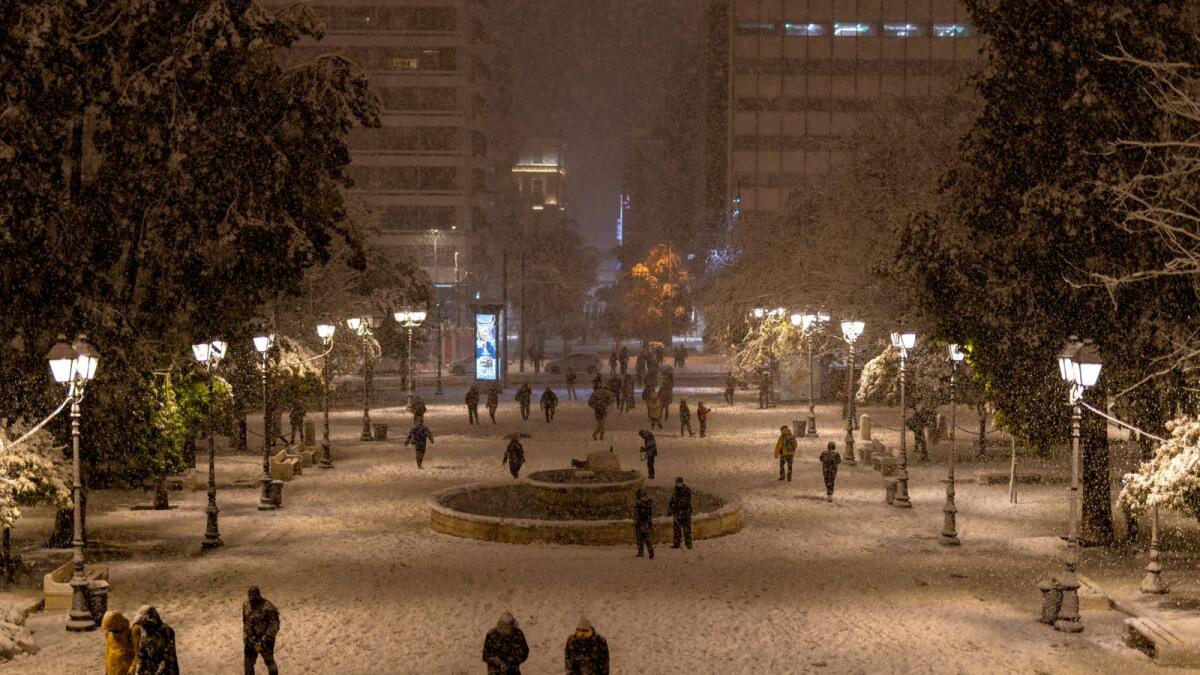 People walk on Syntagma square during heavy snowfall in Athens. (Reuters)
