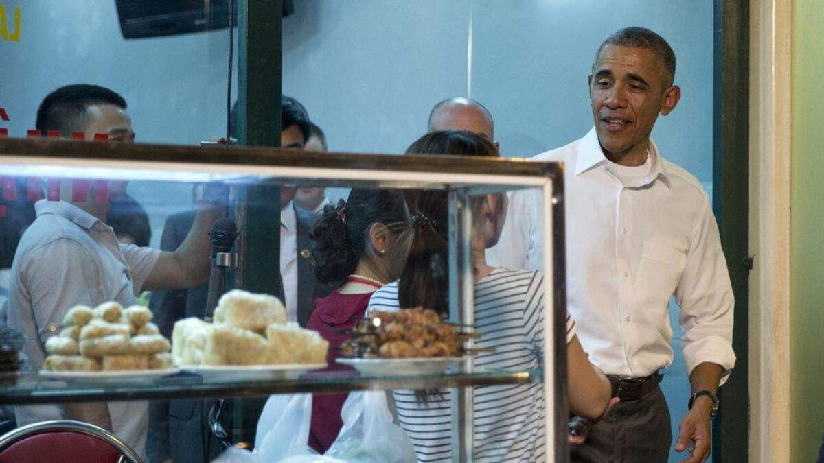 President Barack Obama greets women at the door as he walks from the street side restaurant after having dinner with American Chef Anthony Bourdain in Hanoi, Vietnam. 