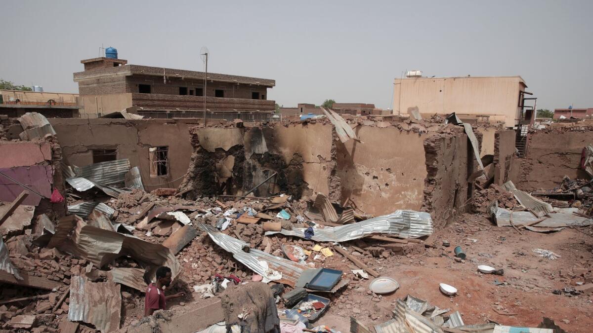 A man walks by a house hit in recent fighting in Khartoum, Sudan. — AP
