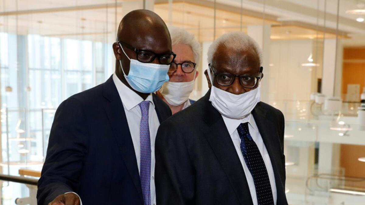 Lamine Diack (right) arrives at a Paris court on Monday. -- AFP