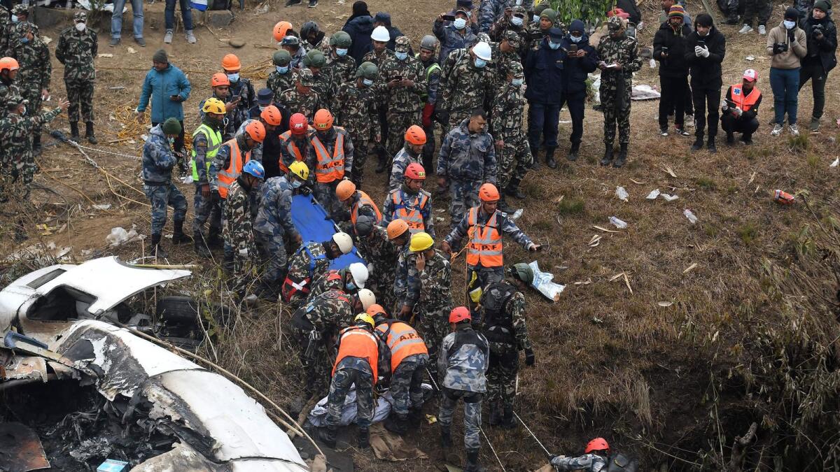 Rescuers prepare to carry the body of a victim who died in a Yeti Airlines plane crash in Pokhara. — AFP