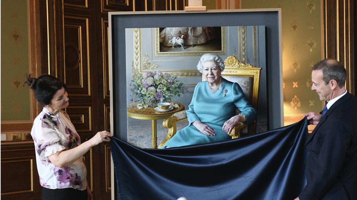 Undated handout photo released by the Royal Communications, showing the unveiling in London of a new portrait of Britain's Queen Elizabeth II by artist Miriam Escofet, left, with Simon McDonald, Permanent Under-Secretary of State for Foreign and Commonwealth Affairs and Head of the Diplomatic Service, right. The painting was commissioned by the Foreign and Commonwealth Office (FCO), as a 'lasting tribute to her service' to diplomacy. The Queen paid a virtual visit to the FCO via video call, to hear about their response to the Covid-19 outbreak and join the unveiling of the new portrait.  Photo: AP