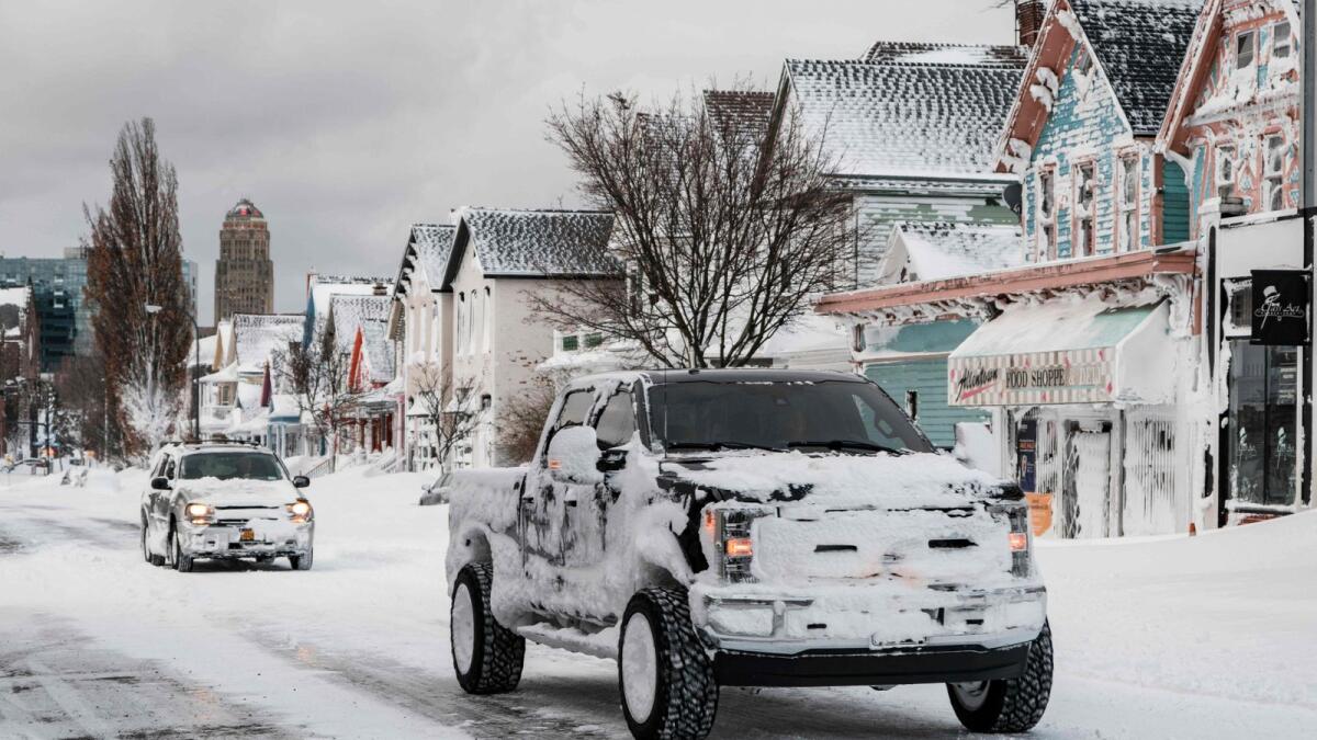 Snow-covered vehicles make their way down Elmwood Avenue in Buffalo. — AFP
