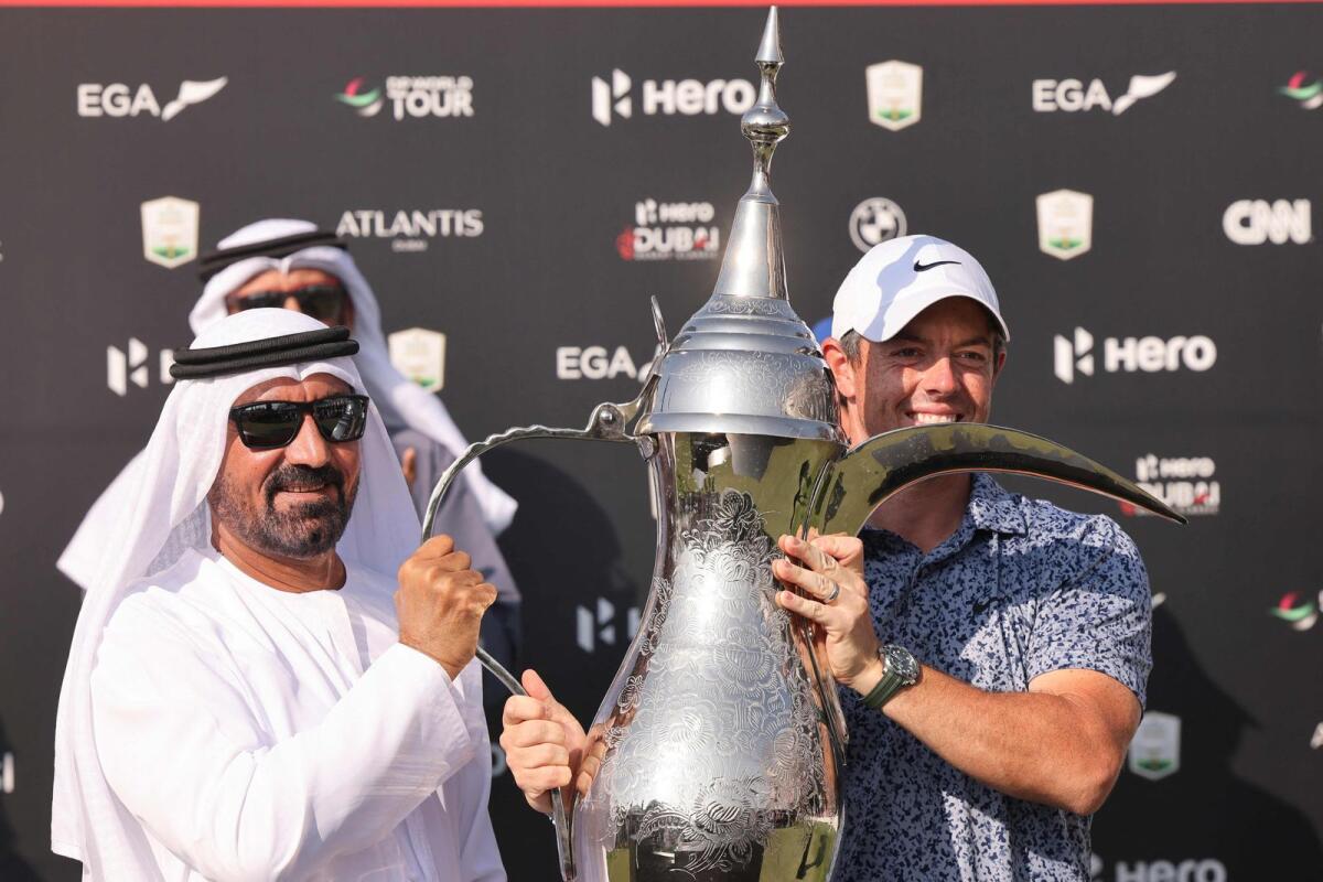 Sheikh Ahmed bin Saeed Al Maktoum, CEO of the Emirates Group, presents the trophy to Rory McIlroy of Northern Ireland. — AFP