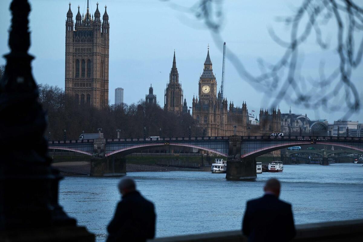 Pedestrians walk along the Southbank by the River Thames, with The Elizabeth Tower, commonly known by the name of the clock's bell 'Big Ben', at the Palace of Westminster, home to the Houses of Parliament, in the background in central London, on Wednesday. — AFP