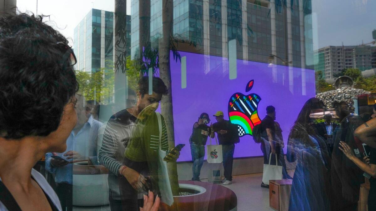 People take selfies inside the first Apple Inc. flagship store as others watch from outside, in Mumbai last month. Apple Inc. opened its first flagship store in India in a much-anticipated launch Tuesday that highlights the company’s growing aspirations to expand in the country it also hopes to turn into a potential manufacturing hub.  — AP