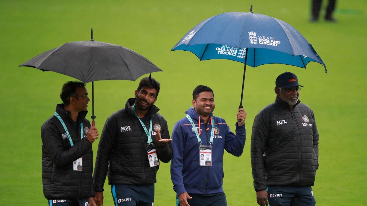 India's Jasprit Bumrah (second left) gestures as he walks with members of team support staff after rain delayed start of the fourth day. — AP