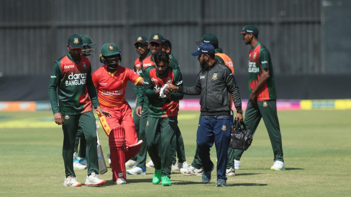 Bangladesh bowler Mehidy Hasan Miraz (centre) leaves the pitch after sustaining  an injury on his finger during the second ODI.— AP