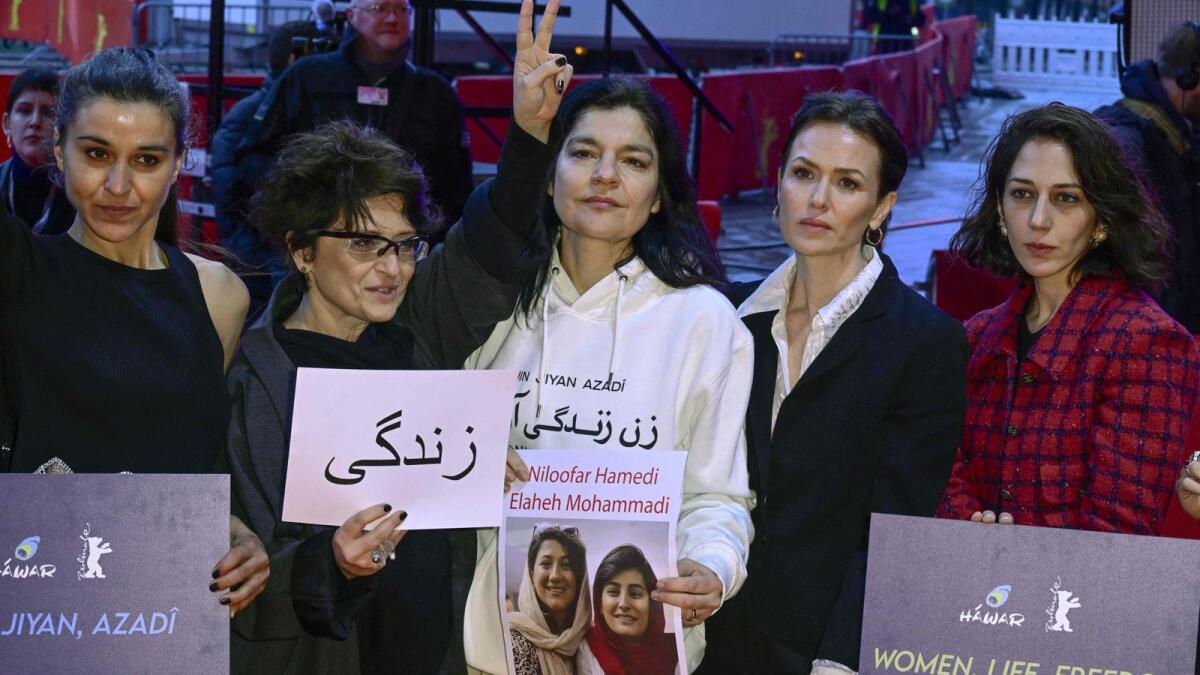 Iranian film director Sepideh Farsi Press (2ndL) and German actress Jasmin Tabatabai (C) among others attend a protest in solidarity with protesters in Iran on the red carpet at Berlin Film Festival the Berlinale on Saturday in Berlin. — AFP