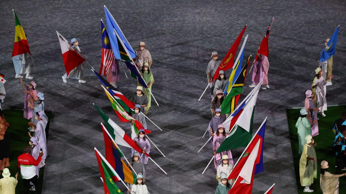 The flags of participating countries are carried at the closing ceremony.— Reuters
