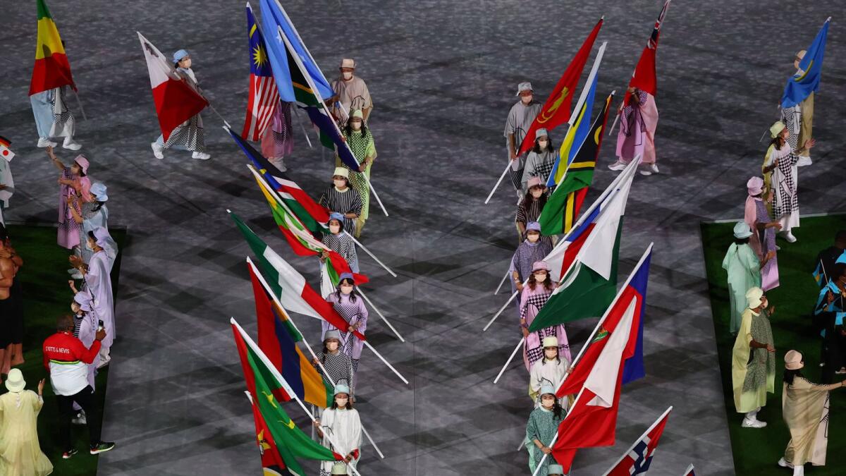 The flags of participating countries are carried at the closing ceremony.— Reuters