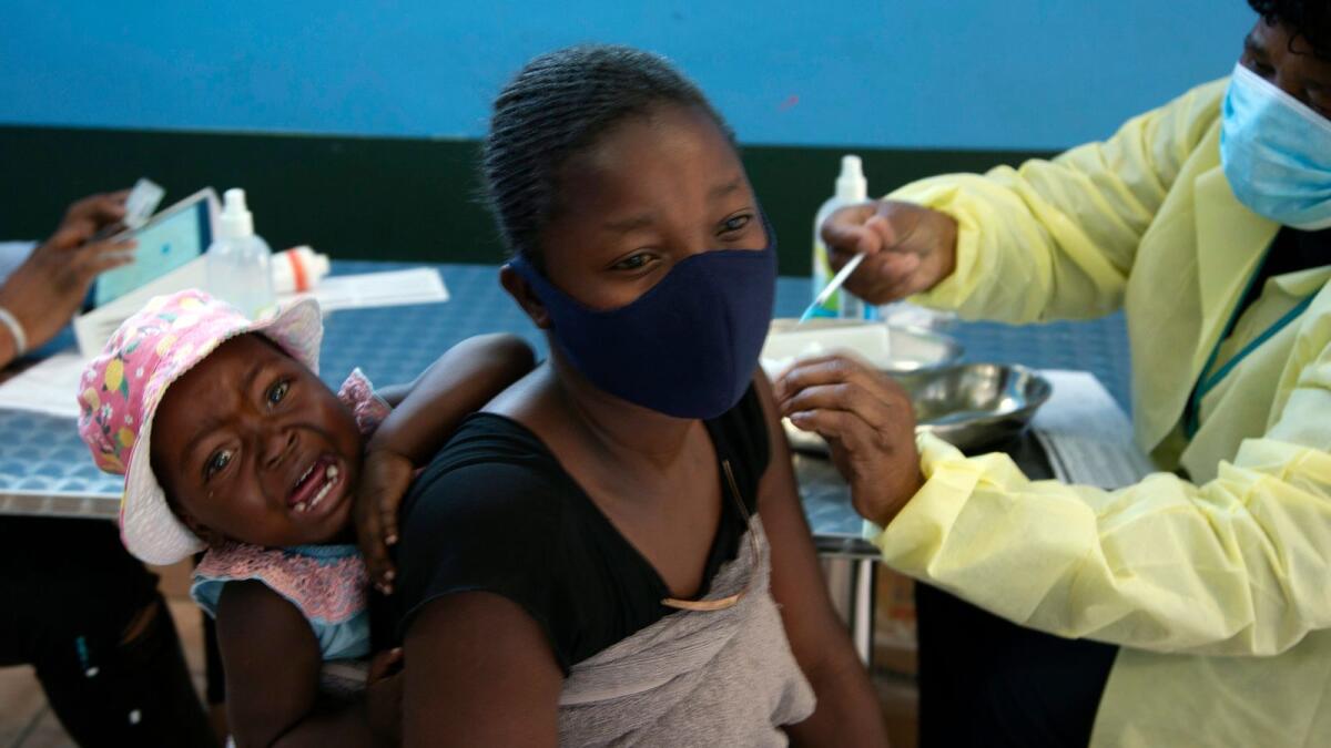 FILE - A baby cries as her mother receives her Pfizer vaccine against COVID-19, in Diepsloot Township near Johannesburg Thursday, Oct. 21, 2021. A new COVID-19 variant has been detected in South Africa that scientists say is a concern because of its high number of mutations and rapid spread among young people in Gauteng, the country's most populous province, Minister of Health Joe Phaahla announced Thursday, Nov. 25, 2021. (AP Photo/Denis Farrell, File)