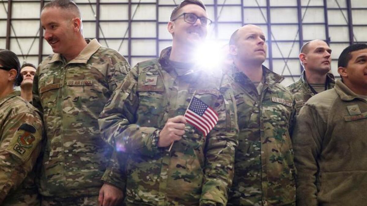 A United States Airman holds up an American flag as President Donald Trump delivers remarks to military personnel in an unannounced visit to Bagram Air Base, Afghanistan. Reuters