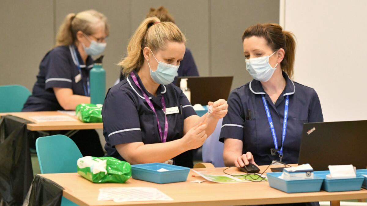 Staff prepare for the opening of a mass vaccination centre at Epsom racecourse in southern England. Photo: AFP