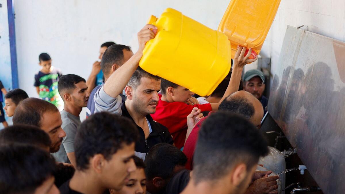 Palestinians gather to collect water, amid shortages of drinking water. Photo: Reuters file