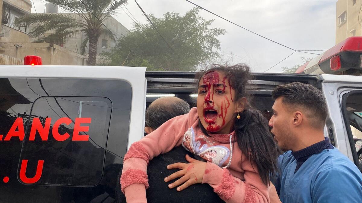An injured Palestinian girl is carried to an ambulance at the site of an Israeli strike in Rafah in the southern Gaza Strip. — Reuters