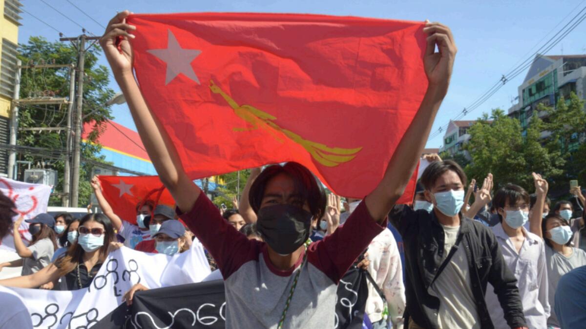 Anti-coup protesters display a party flag of the National League for Democracy (NLD) during a demonstration in Yangon. — AP