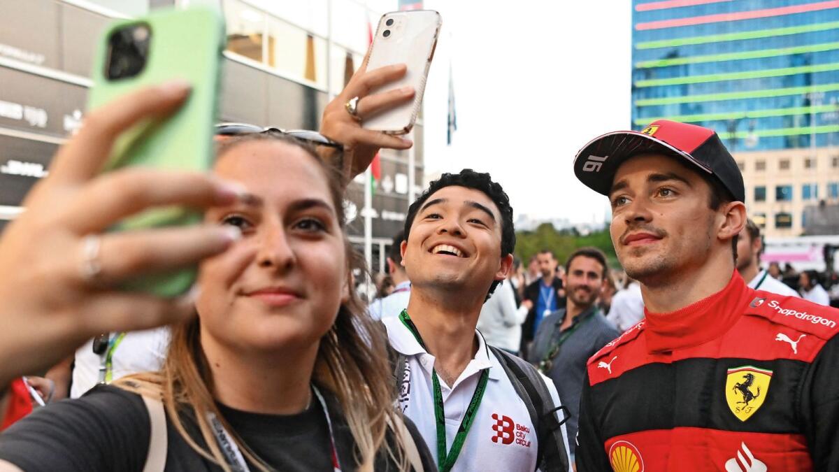Ferrari's Charles Leclerc poses for pictures with fans after the qualifying session. — AFP