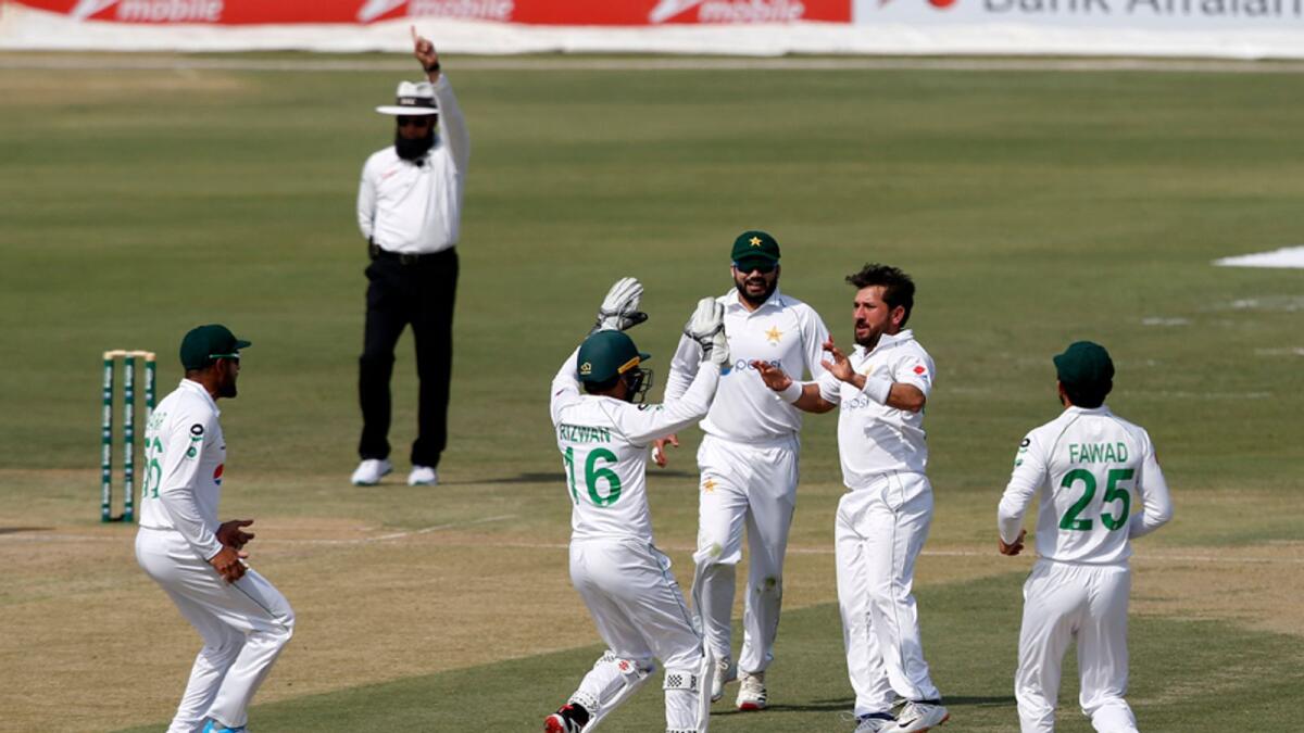 Pakistan's spinner Yasir Shah celebrates with teammates the dismissal of South Africa's Faf du Plessis during the first day of the first cricket Test match. — AP